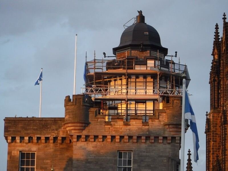 Restored cupola with dome roof and surrounding scaffolding on an Edinburgh landmark building, Scottish flags flying